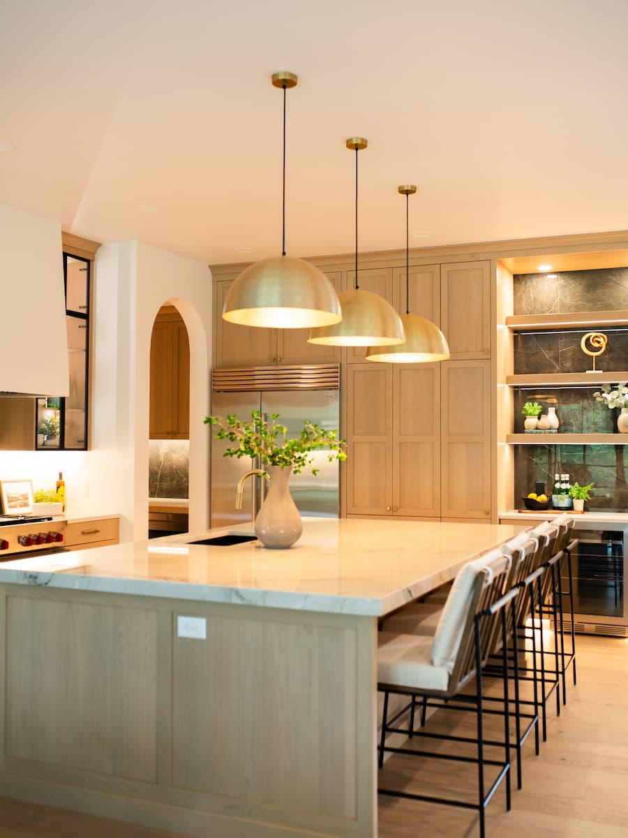 Warm white oak kitchen with brass pendants