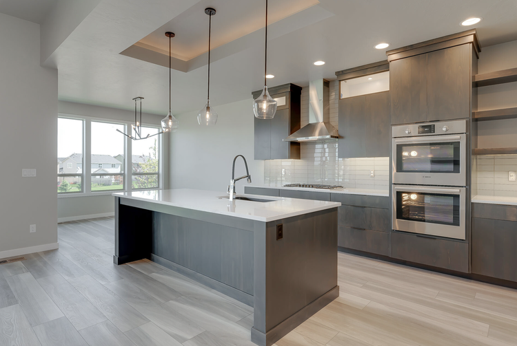 Greyloch Gray Kitchen with Dark Island and Wall Ovens gray kitchen with dark island, wall ovens and large windows